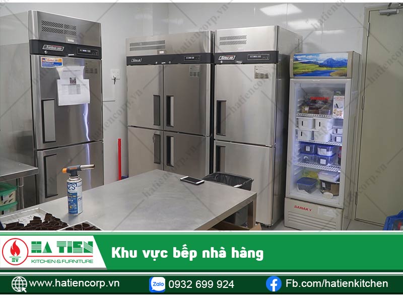Khu vực chuẩn bị thức ăn với bàn inox, các loại tủ đông, tủ lạnh